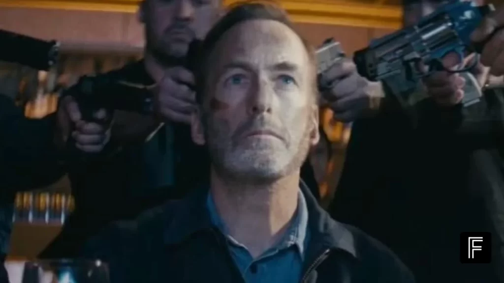 Bob Odenkirk as Hutch Mansell holding a weapon in an intense action scene from Nobody 2.