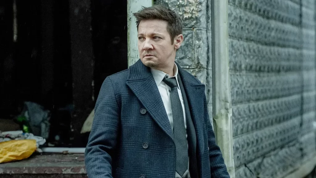 Jeremy Renner’s Mike McLusky standing alone in atmospheric solo frame from Season 4.