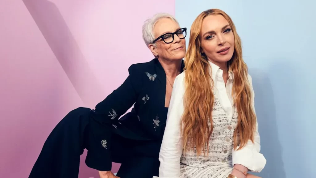 Lindsay Lohan and Jamie Lee Curtis smiling and leaning toward the camera in a vibrant, stylized shot from Freakier Friday (2025)