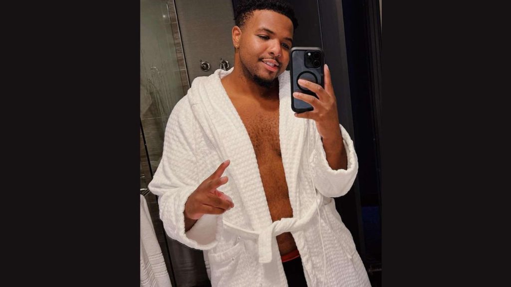 Malik Taylor, popular TikTok creator, captured in a candid moment with a bright smile.