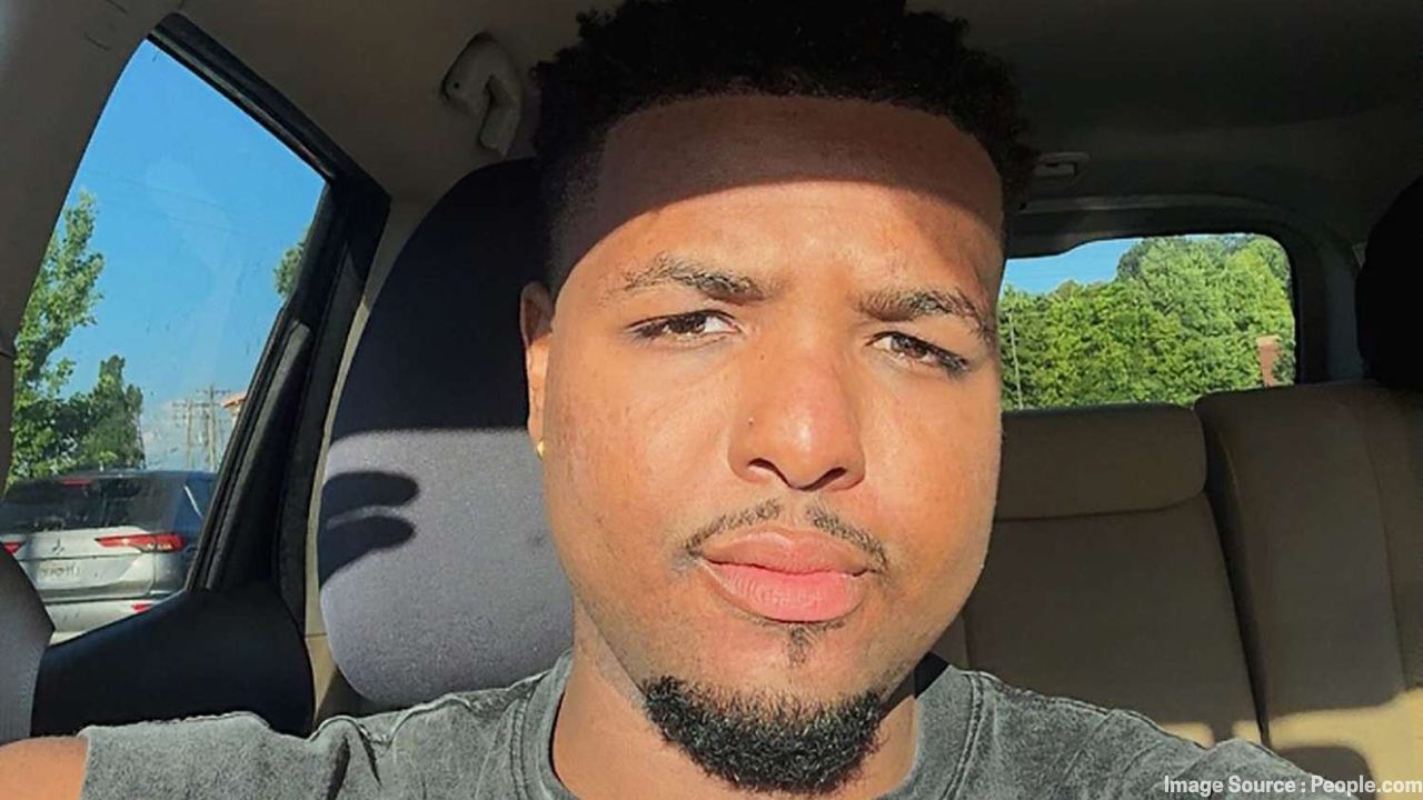 TikTok star Malik Taylor smiling in a casual selfie inside a car, remembered after his passing at 28.