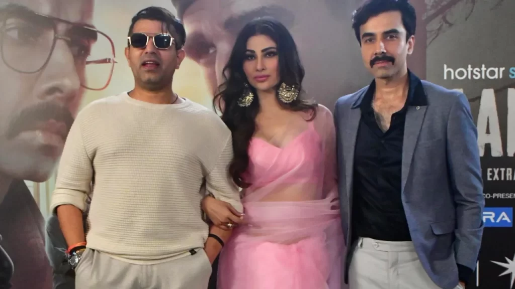 Mouni Roy, Naveen Kasturia, and director Faruk Kabir at a media event, exuding style and intrigue.