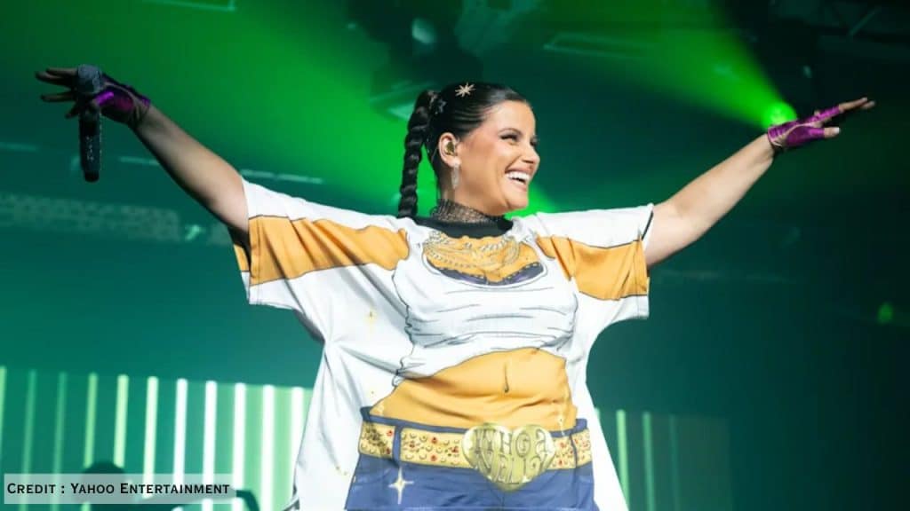 Nelly Furtado performs in fishnet tights, gloves, and statement T-shirt with “Whoa Nelly” belt, inspiring fans.