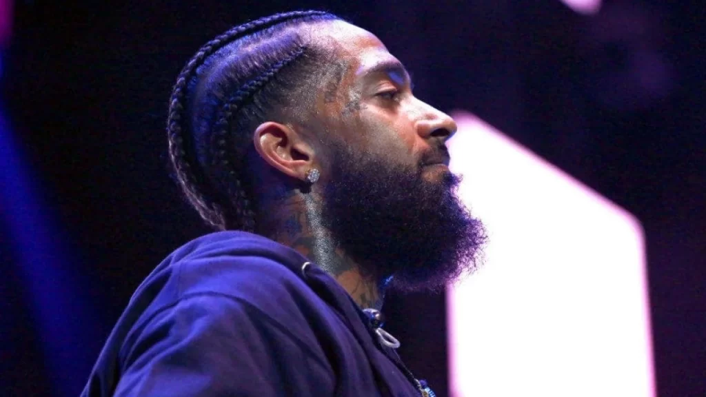 Respectful portrait of Nipsey Hussle displayed during a public tribute, symbolizing his cultural and community impact.