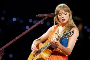 Taylor Swift posing with Portofino orange glitter vinyl for her new album The Life of a Showgirl during podcast reveal.