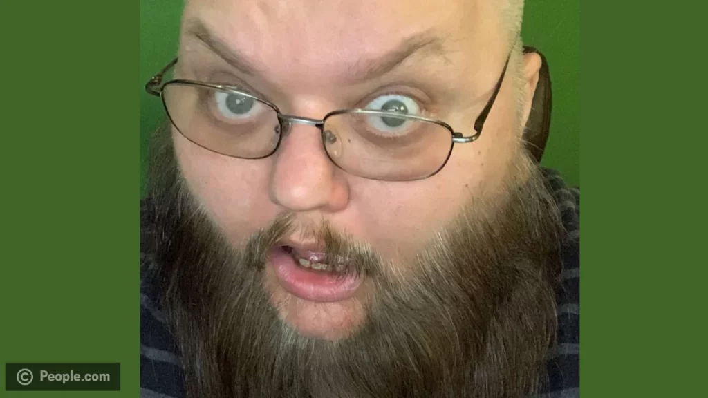 John Crawley known as KingBeardX with glasses and noticeable beard — featured in online tributes following his death.
