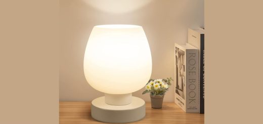 Modern touch bedside table lamp placed on a wooden nightstand in a cozy bedroom.