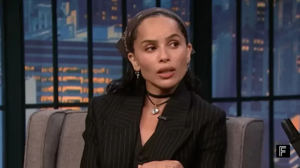 Zoë Kravitz animatedly describing her wild bathroom mishap on Late Night with Seth Meyers.
Description A candid interview still where Kravitz shares the humorous and chaotic story of staying with Taylor Swift during the LA wildfires.