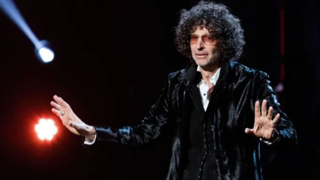 Howard Stern in studio promotional image with SiriusXM branding gesture, representing his long-running presence on satellite radio.