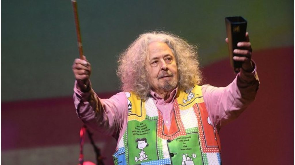 Mark Volman, arms raised and vibrant, leading a concert with joy and charisma