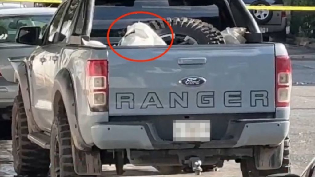 Rear view of the Ford Ranger pickup truck, showing its tailgate and license plate area, at the scene where forensic evidence was collected following the murders.