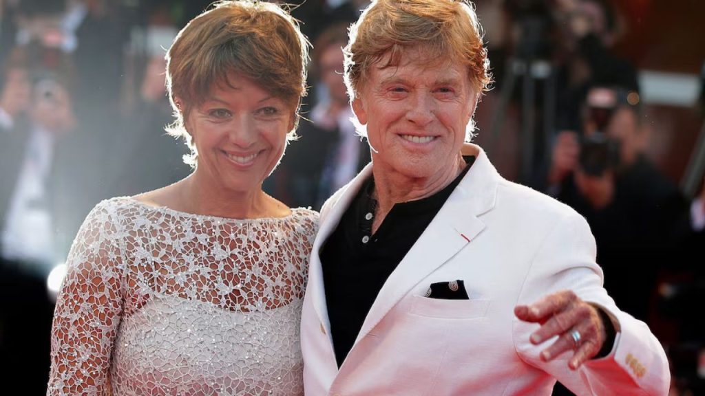 Director Robert Redford and wife Sibylle Szaggars posing on the red carpet during a movie screening.
