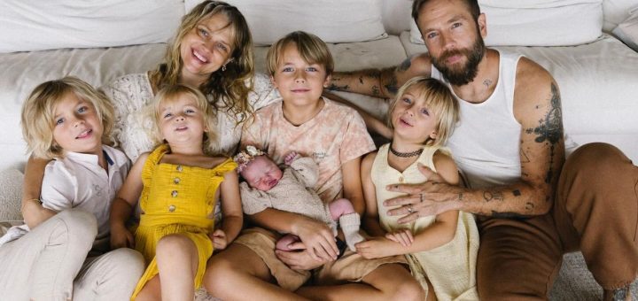 The Palmer-Webber family of eight posing together in their backyard.